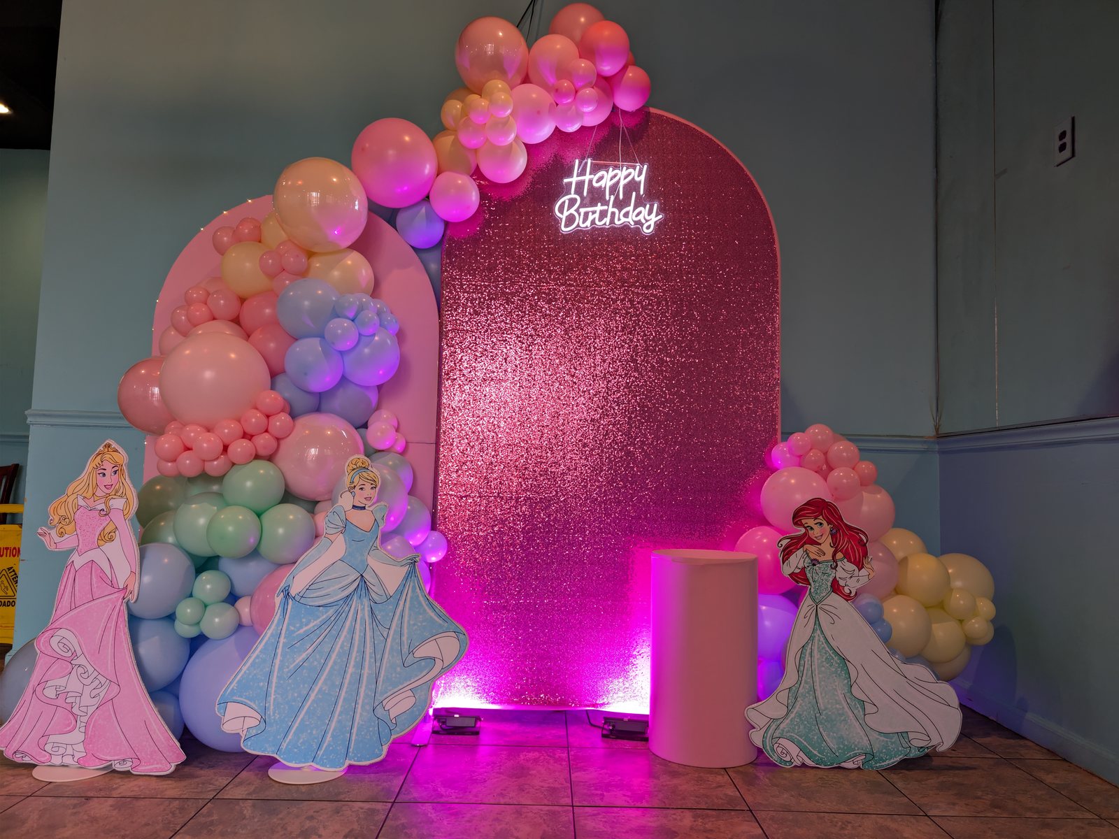 Princess birthday backdrop with blush balloons, shimmer wall, custom signage, and uplighting